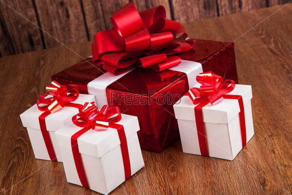 one red gift box white gift boxes on a wood background