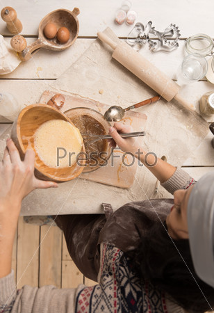 Woman baking Christmas cookies in her kitchen. Top view