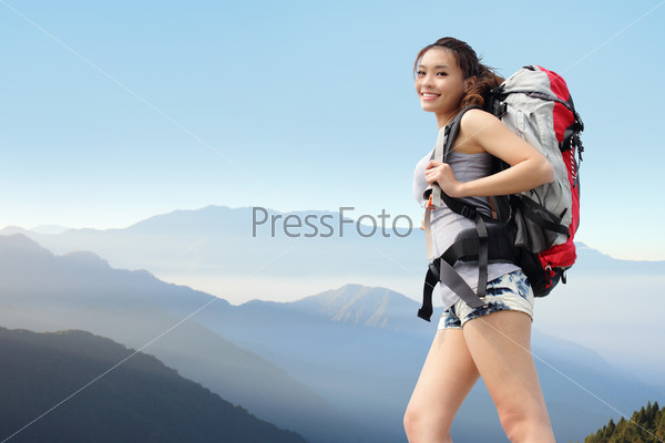 happy woman mountain hiker with backpack and smile to you on the top of mountains. asian