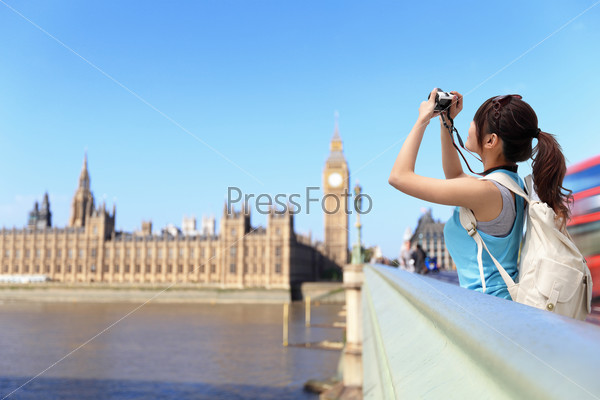 Happy woman traveler take photo by camera in London with Big Ben tower, London, UK, asian beauty
