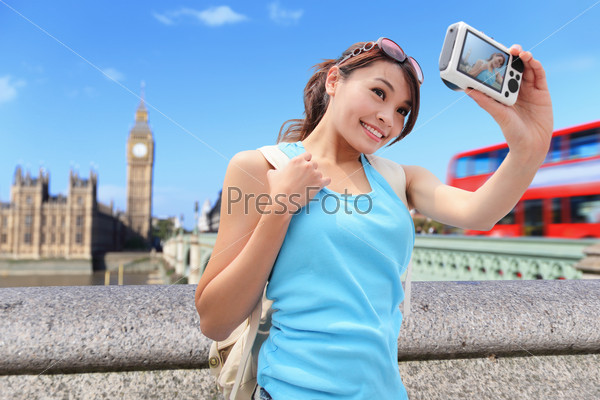 Happy woman traveler take photo selfie by camera in London with Big Ben tower,  London, UK,  asian beauty