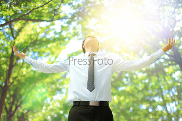 Deep breathing carefree business man with tree in the forest, asian