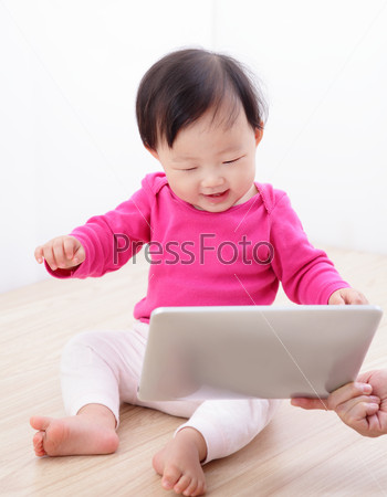 Girl baby happy watch tablet PC with excited smile. asian child