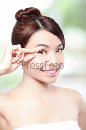 Beautiful woman smile face and finger touch her eyes with clean face skin, concept for eye and skin care, over nature green background, asian beauty
