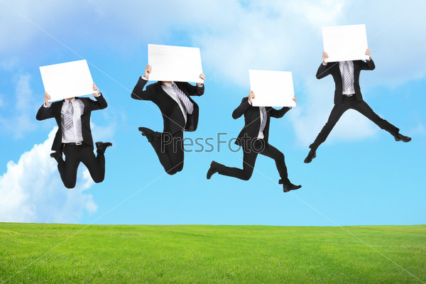 Business man happy holding empty billboard and jumping or running on the green grass