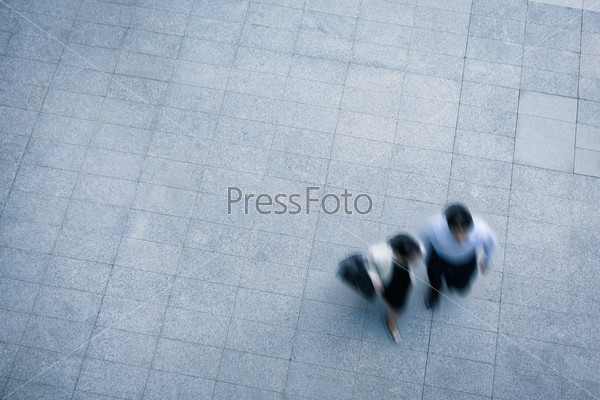 Business people walking and talking in the street, high angle view