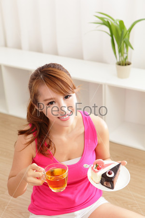 Young woman with a cake and tea