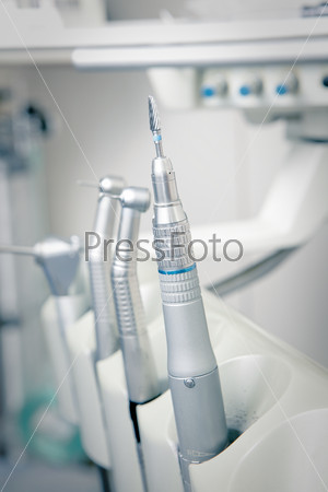 Metallic dentist tools close up on a dentist chair in Dentist Clinic (blue tone)
