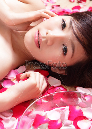 Asian beauty Girl face close up with rose background, Beautiful young woman touching her face