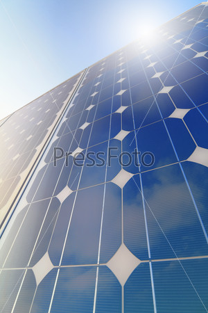 Solar cell battery panel detail and close-up with cloud sky and sun reflection