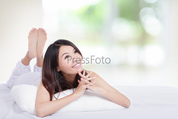 Waiting for the dream come true, Charming woman lying on the bed and looking to empty copy space in the morning, model is a asian girl