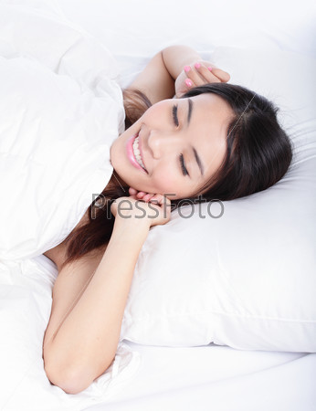 Sleeping woman wake up in the morning lying on bed at home, model is a asian girl