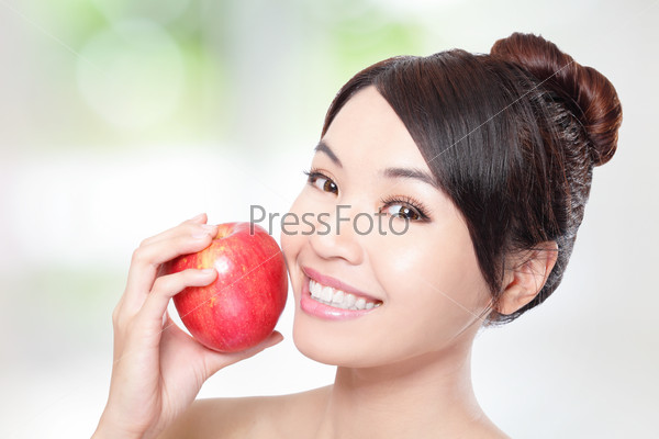 Young woman eating red apple with health teeth