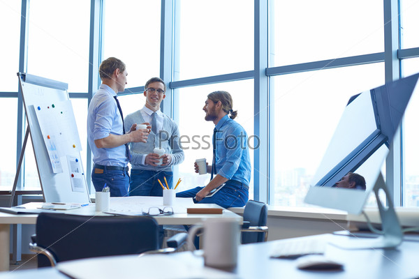 Group of contemporary businessmen consulting about their work in office, stock photo