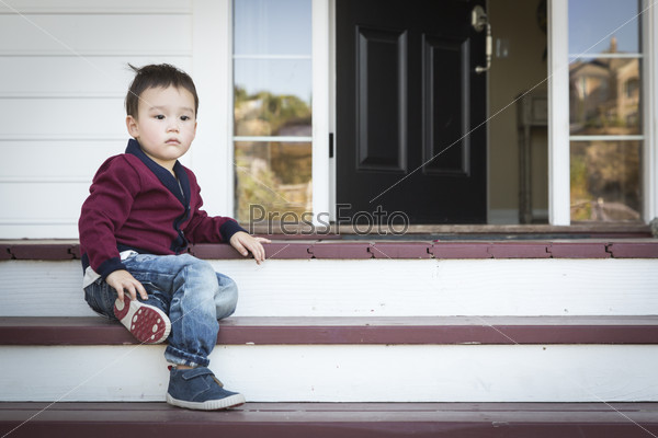 Cute Melancholy Mixed Race Boy Sitting on Front Porch Steps.