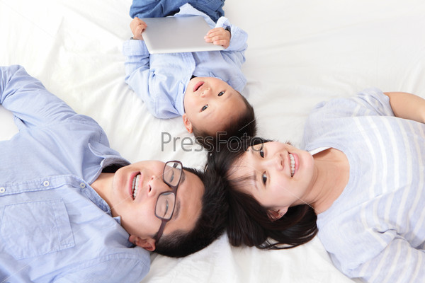 happy, family of mother, father, son using tablet computer pc on bed at home, focus on child, asian people