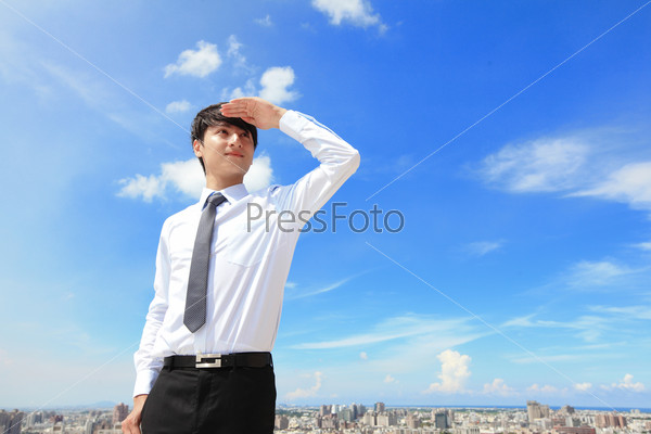 Successful handsome business man purposefully looking away with blue sky and city background, mode is a asian male