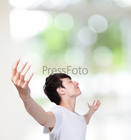 young man carefree outstretched arms with green background, healthy lifestyle concept, asian people