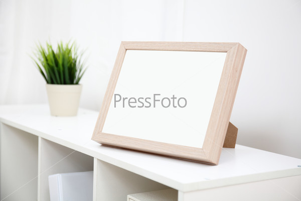blank photo frame with copy space on white bookshelf at home