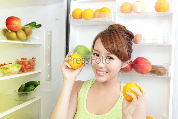 Healthy Eating Concept .Diet. Beautiful Young Woman near the Refrigerator with healthy food. Fruits and Vegetables, asian model