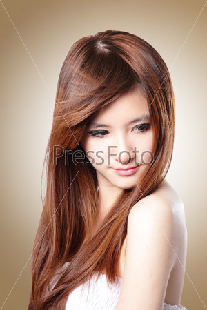 Brown Hair. Fashion Beautiful Woman with Hair in wind isolated on brown background, asian beauty