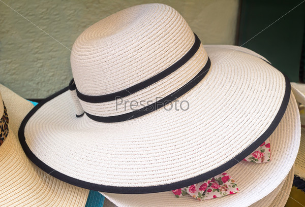 Women\'s summer hat with large brim, decorated with black ribbon, for protection from the sun.