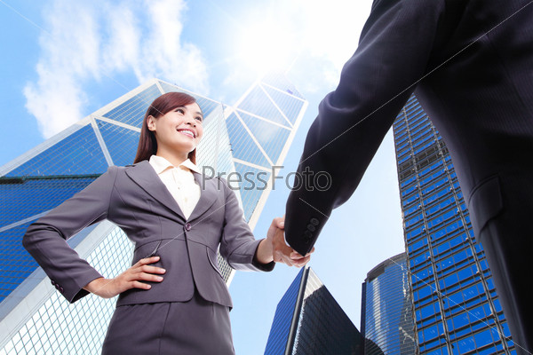 Business woman and man handshake with business office building background, asian, hong kong