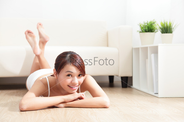 Young beauty with perfect  figure in white underwear leisurely lying on floor