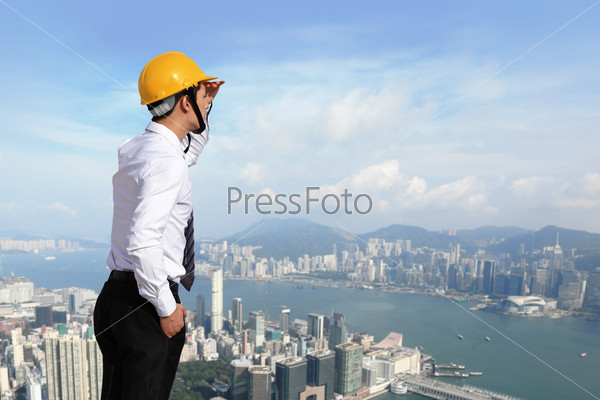 architect with helmet looking city building