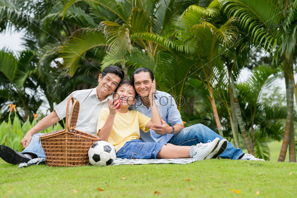Son, father and grandfather having picnic in the park