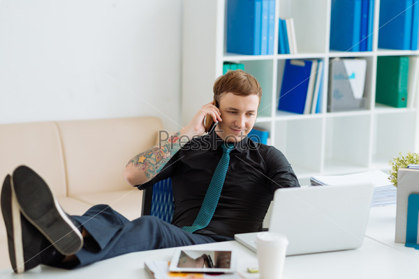 Modern businessman working at the office with his legs on the table