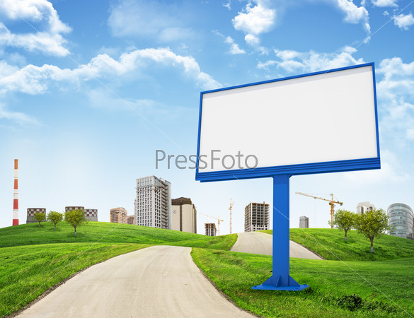 Tall buildings, green hills and road with large billboard against sky with clouds. Architectural concept