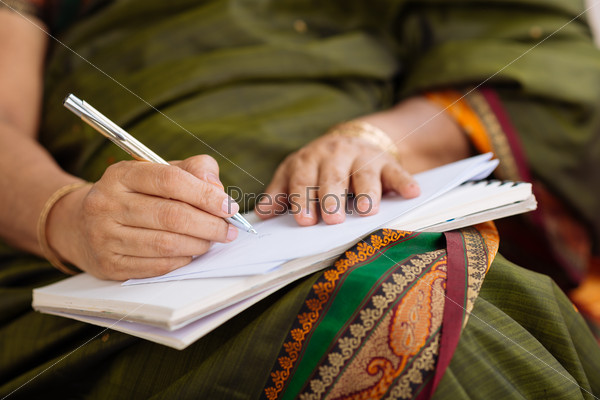 Hands of Indian woman writing a letter