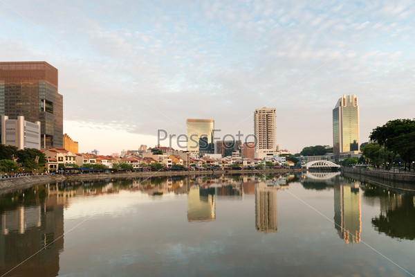 Singapore quay skyline at morning with small restaurants on Boat Quay and sky reflection in Singapore river