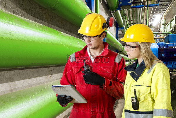 two maintenance engineers going through a checklist during a routine inspection of an industrial installation in a factory