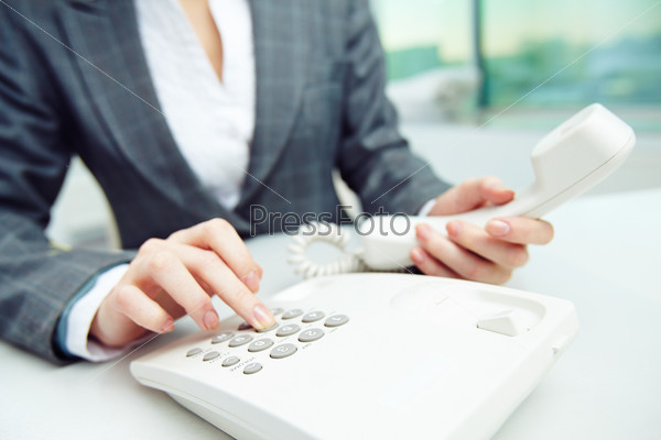 Businesswoman dialing telephone number