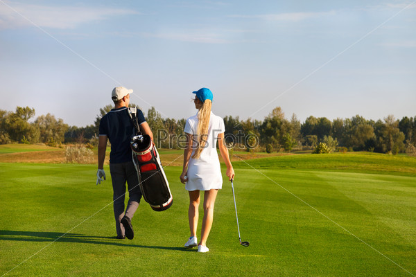 Пара играет в гольф на гольф-поле