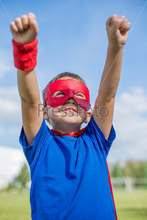 Superhero holding hands up and looking at the sun