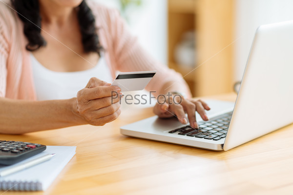 Cropped image of woman inputting card information while shopping online