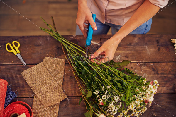 Female florist cutting floral stems with secateurs