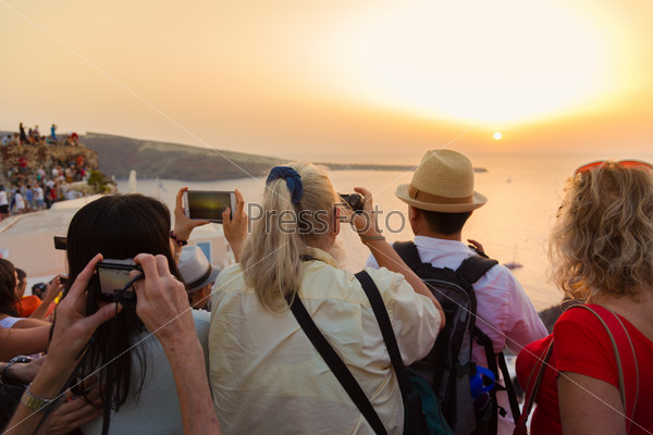 Туристы смотрят на закат в Ия, Санторини, Греция