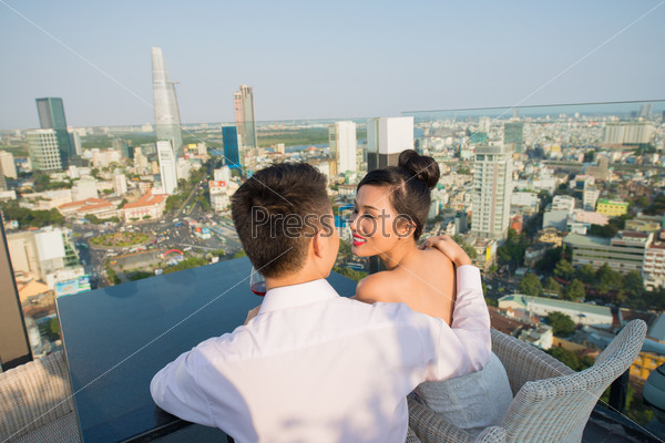 Loving couple enjoying the view on the city from the rooftop restaurant
