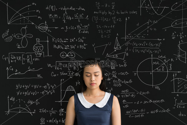 Asian schoolgirl with closed eyes standing in front of chalkboard^ education concept