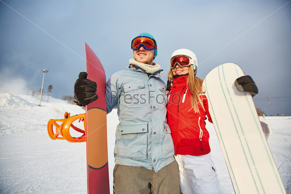 Female and male with snowboards having active leisure
