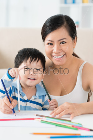 Happy Asian mother and son drawing together