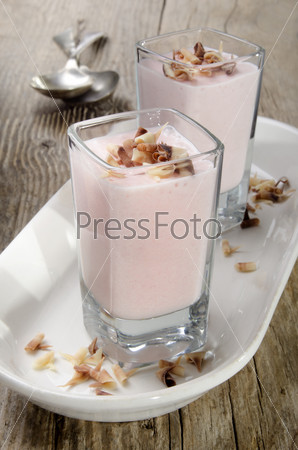 strawberry mousse and chocolate curls in a shot glass on a rustic table