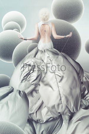 blond woman in long grey dress with spheres