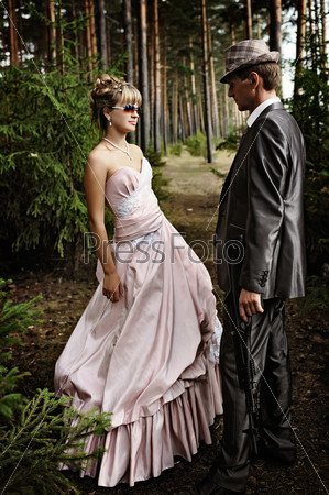 Portrait of two bandits in a wedding dress with a gun, retro style,