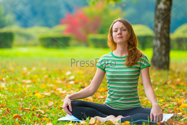 Beautiful girl with a serious expression on his face in the lotus position, stock photo
