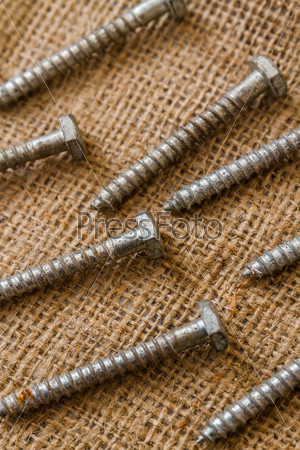 Group of used and old screws on sack fabric
